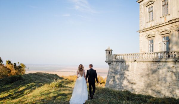 Beautiful couple posing on their wedding day near the mansion